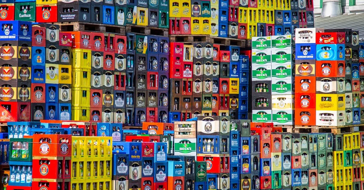 Une exposition vibrante de caisses de bière empilées dans un entrepôt, mettant en valeur différentes marques.
