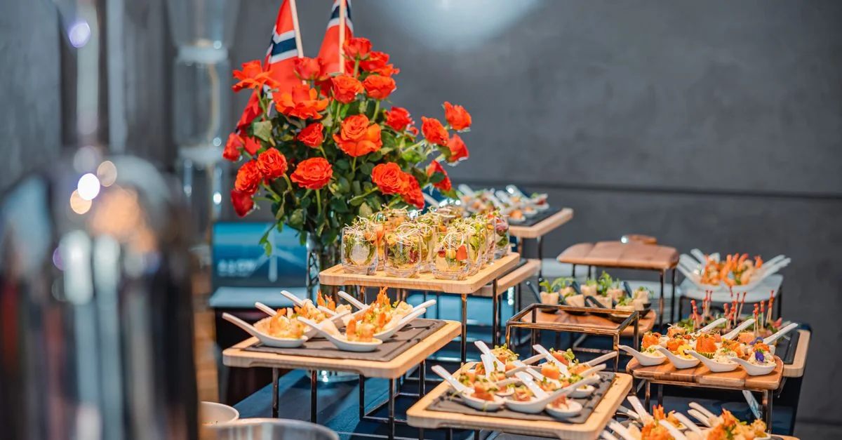 Un buffet luxueux avec des plats gastronomiques, des roses et des décorations de drapeaux à l'intérieur.