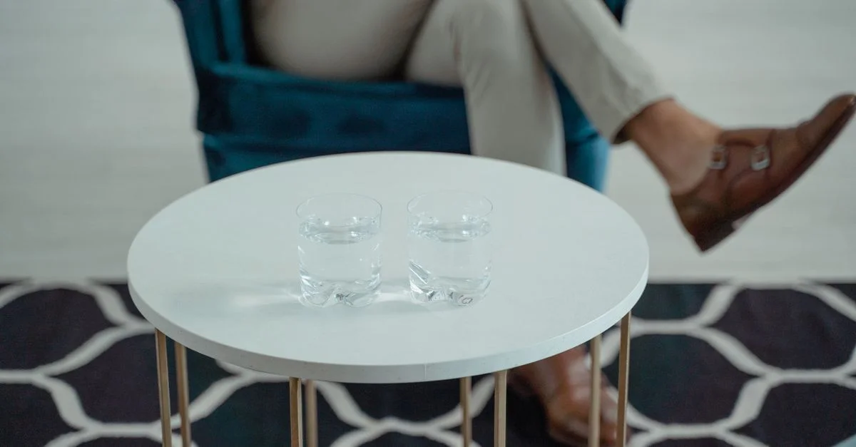 Espace de détente élégant avec deux verres d'eau sur une table ronde.