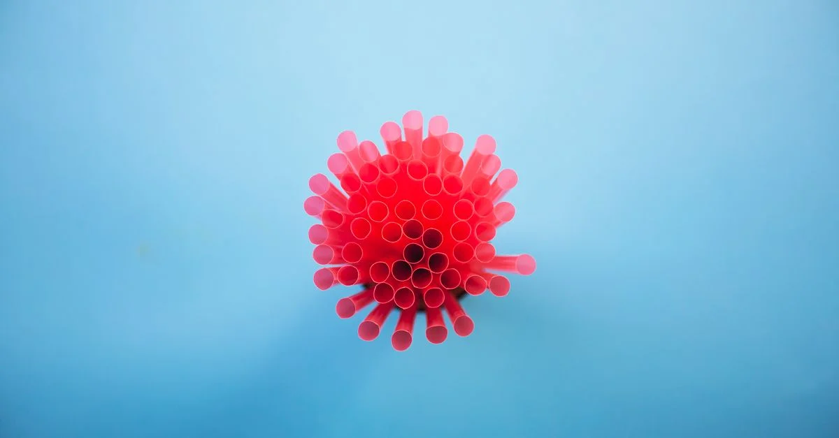 Vue du dessus d'un groupe de pailles en plastique roses sur un fond bleu vif
