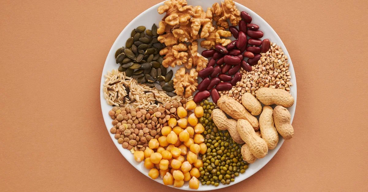 Vue de dessus de noix, haricots et graines sur une assiette, idéale pour des thèmes de repas sains.