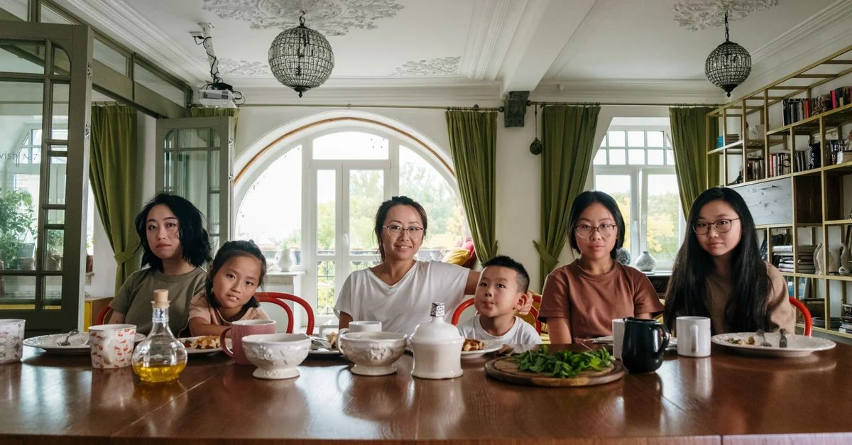 Une famille diversifiée profitant d'un dîner ensemble dans un cadre de salon confortable.