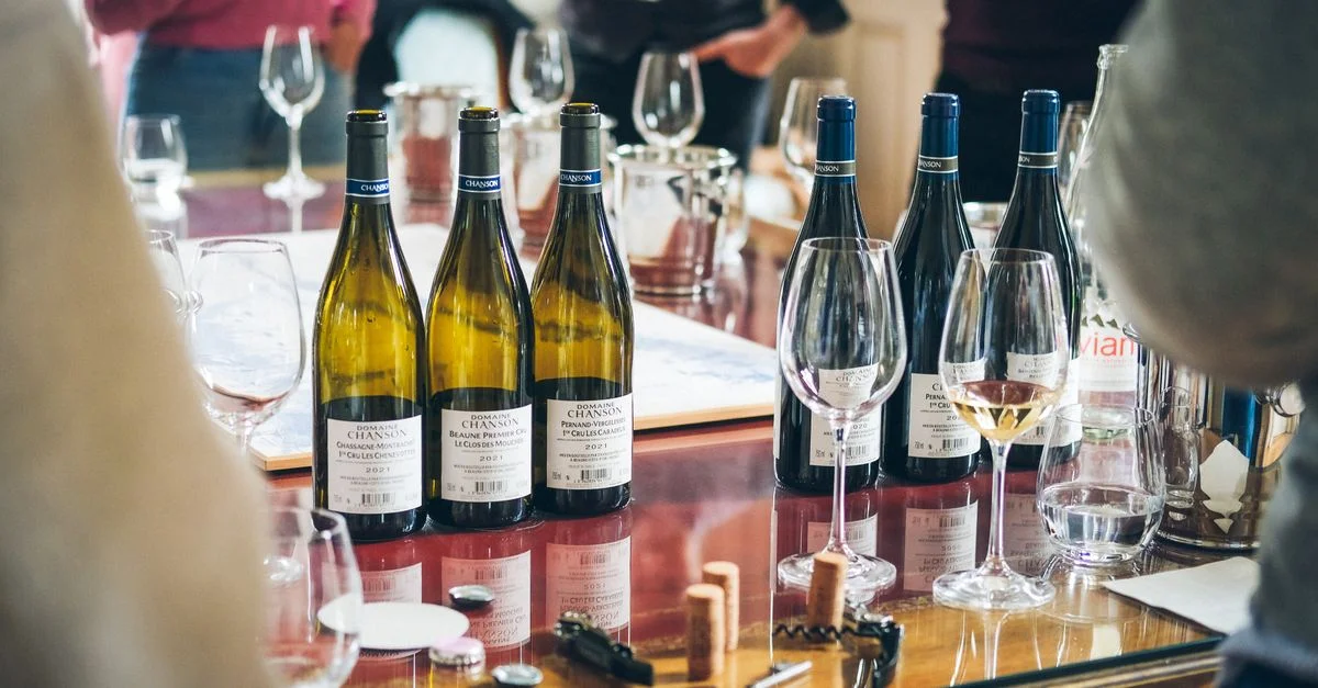 Un événement de dégustation de vin vibrant mettant en avant des bouteilles et des verres sur une table à Beaune, en France.