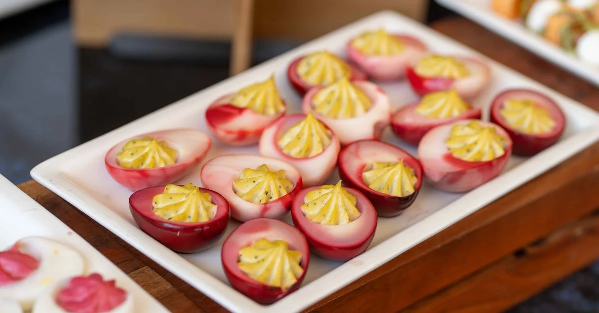Des œufs mimosa colorés à la farce éclatante, élégamment présentés sur un plateau de buffet.