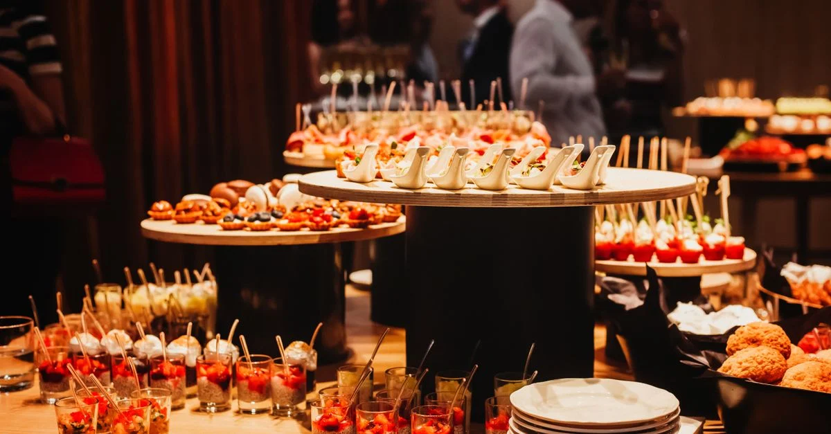 Une variété d'amuse-bouches gastronomiques présentés sur un élégant buffet lors d'un événement en intérieur.