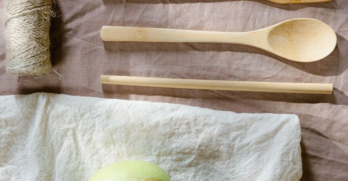 Plan en vue de dessus d'ustensiles en bois et d'une pomme sur un tissu promouvant un mode de vie éco-responsable.