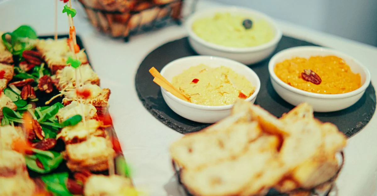 Une variété de dips et d'apéritifs gourmets joliment disposés sur une table, invitants pour des fêtes ou des événements.