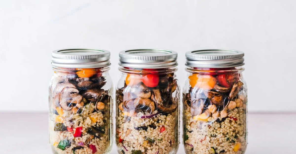 Bocal de salade de quinoa colorée avec des légumes rôtis, idéal pour la préparation de repas sains.
